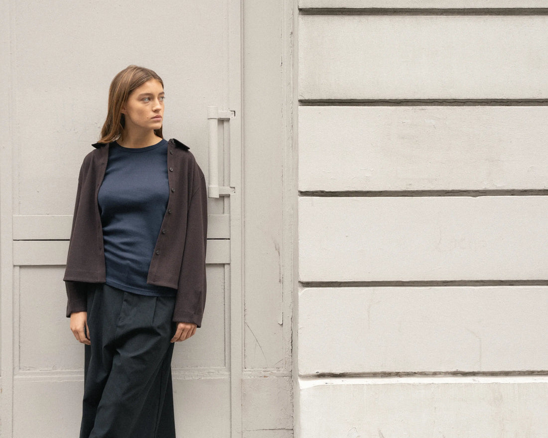 Femme portant un débardeur bleu sous une veste pour un look de rentrée d'automne