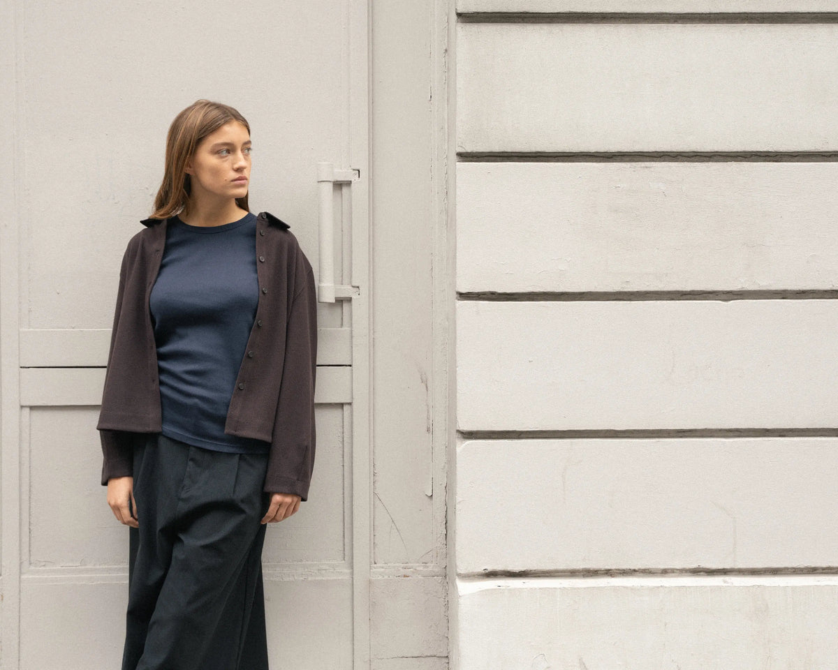 Femme portant un débardeur bleu sous une veste pour un look de rentrée d'automne