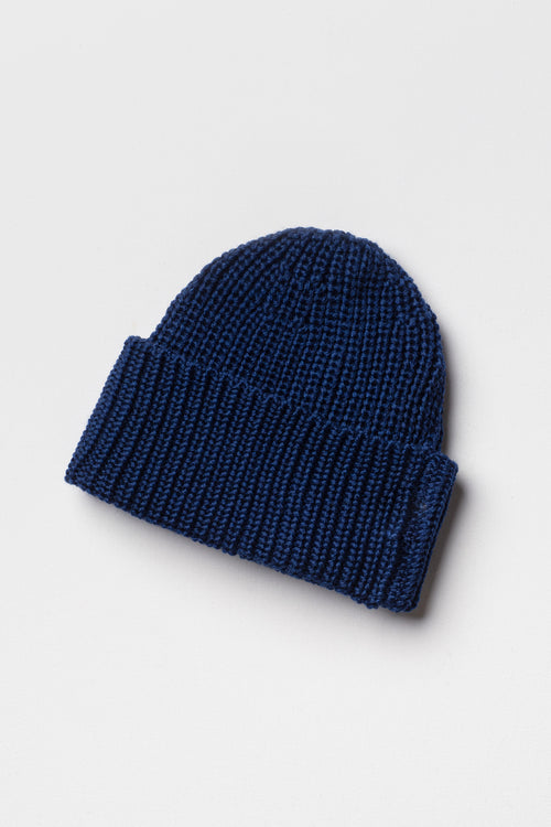 Bonnet bleu en laine mérinos à revers, packshot sur fond clair montrant la maille côtelée. Made in France.