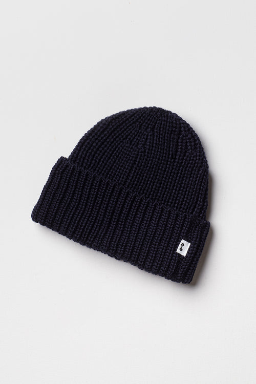 Bonnet homme et femme bleu marine en laine mérinos à revers, packshot sur fond clair montrant la maille côtelée. Made in France.