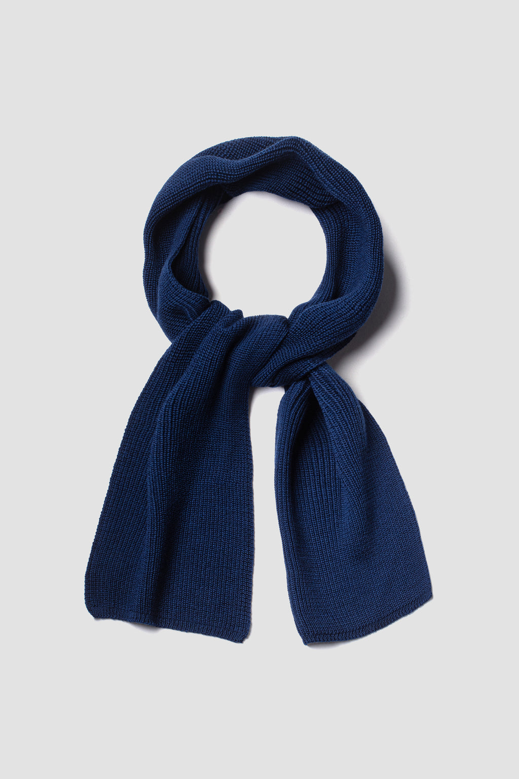 Écharpe bleue en laine mérinos, présentée nouée sur fond clair.