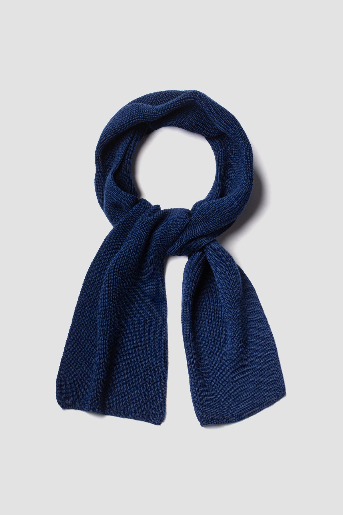Écharpe bleue en laine mérinos, présentée nouée sur fond clair.