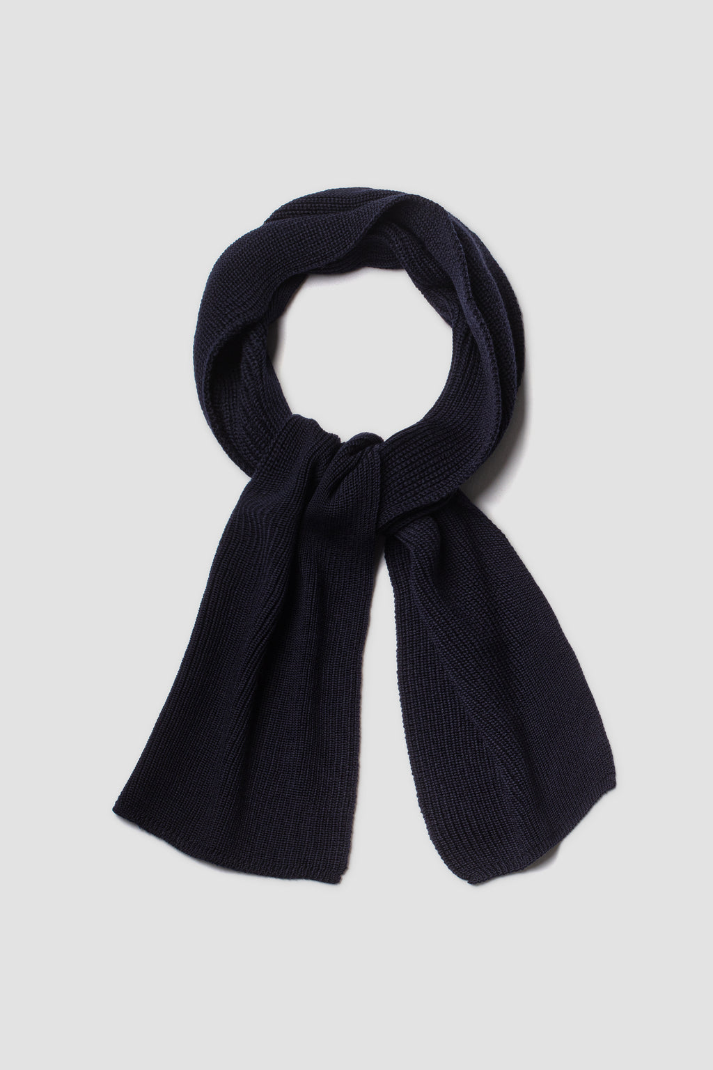 Écharpe homme et femme bleu marine en laine mérinos, présentée nouée sur fond clair.