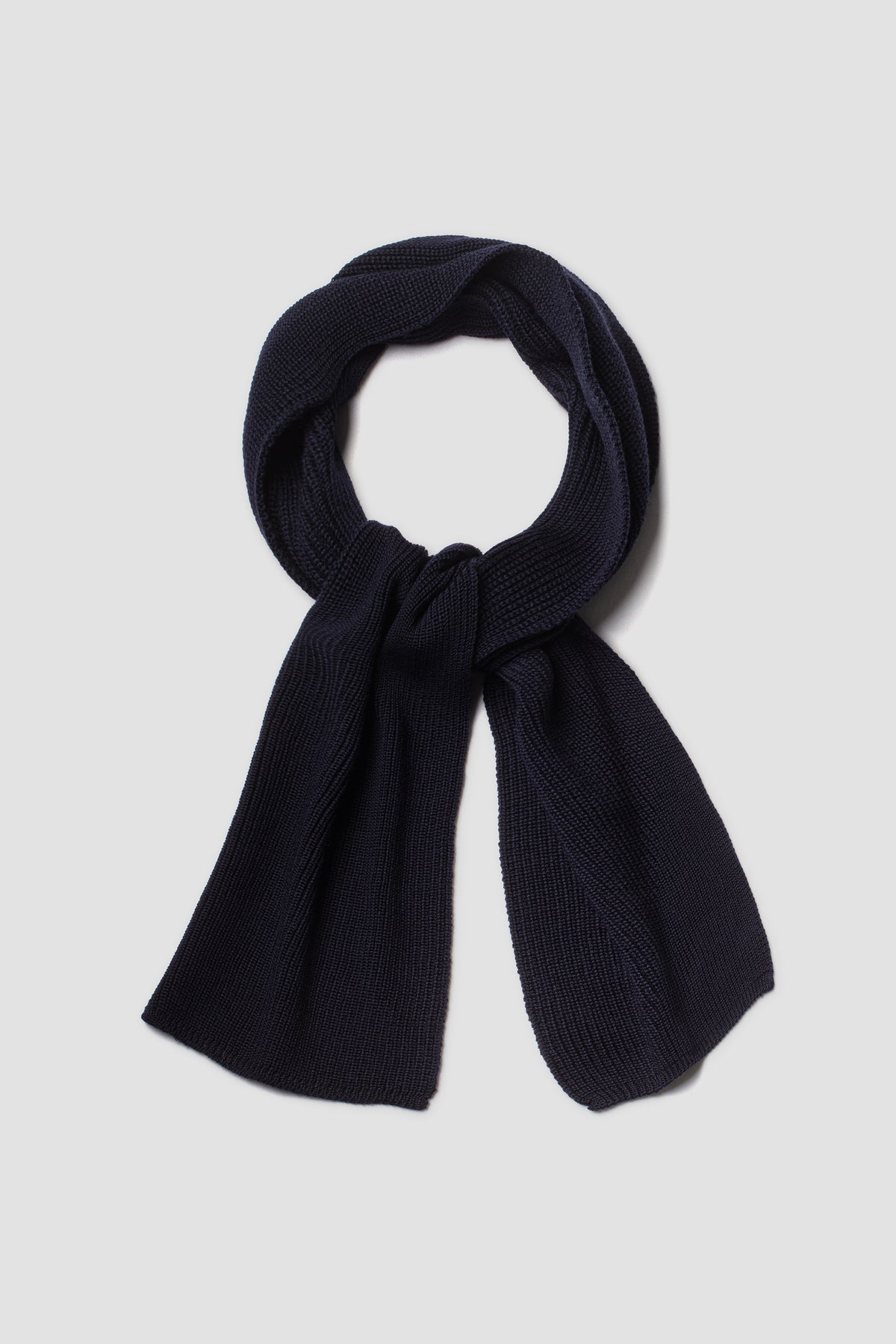 Écharpe homme et femme bleu marine en laine mérinos, présentée nouée sur fond clair.