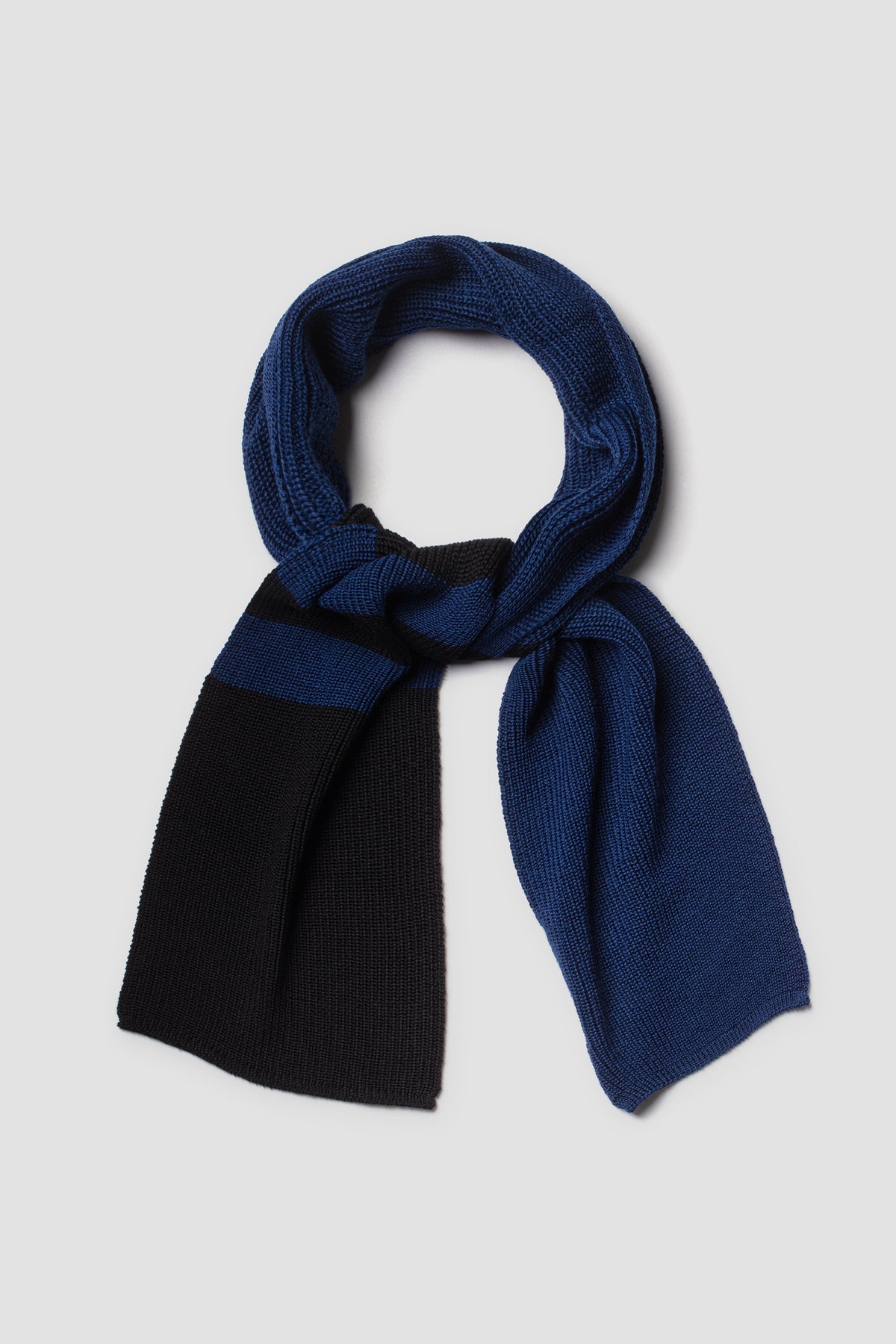 Écharpe Rayée Bleu et Noir en Laine Mérinos, présentée nouée sur fond clair.