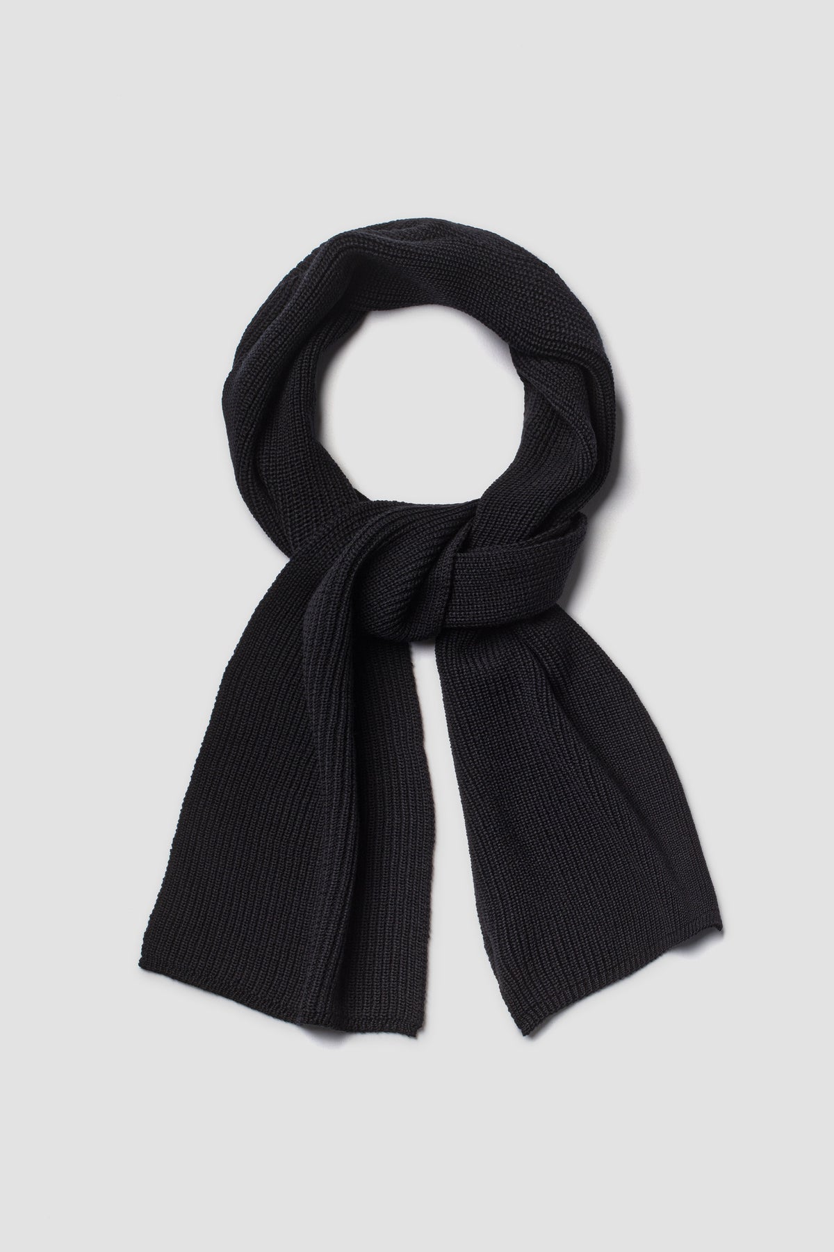 Écharpe homme et femme noire en laine mérinos, présentée nouée sur fond clair.