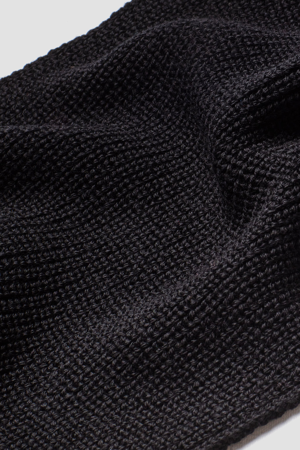 Écharpe homme et femme noire en laine mérinos, gros plan de la maille. Made in France.