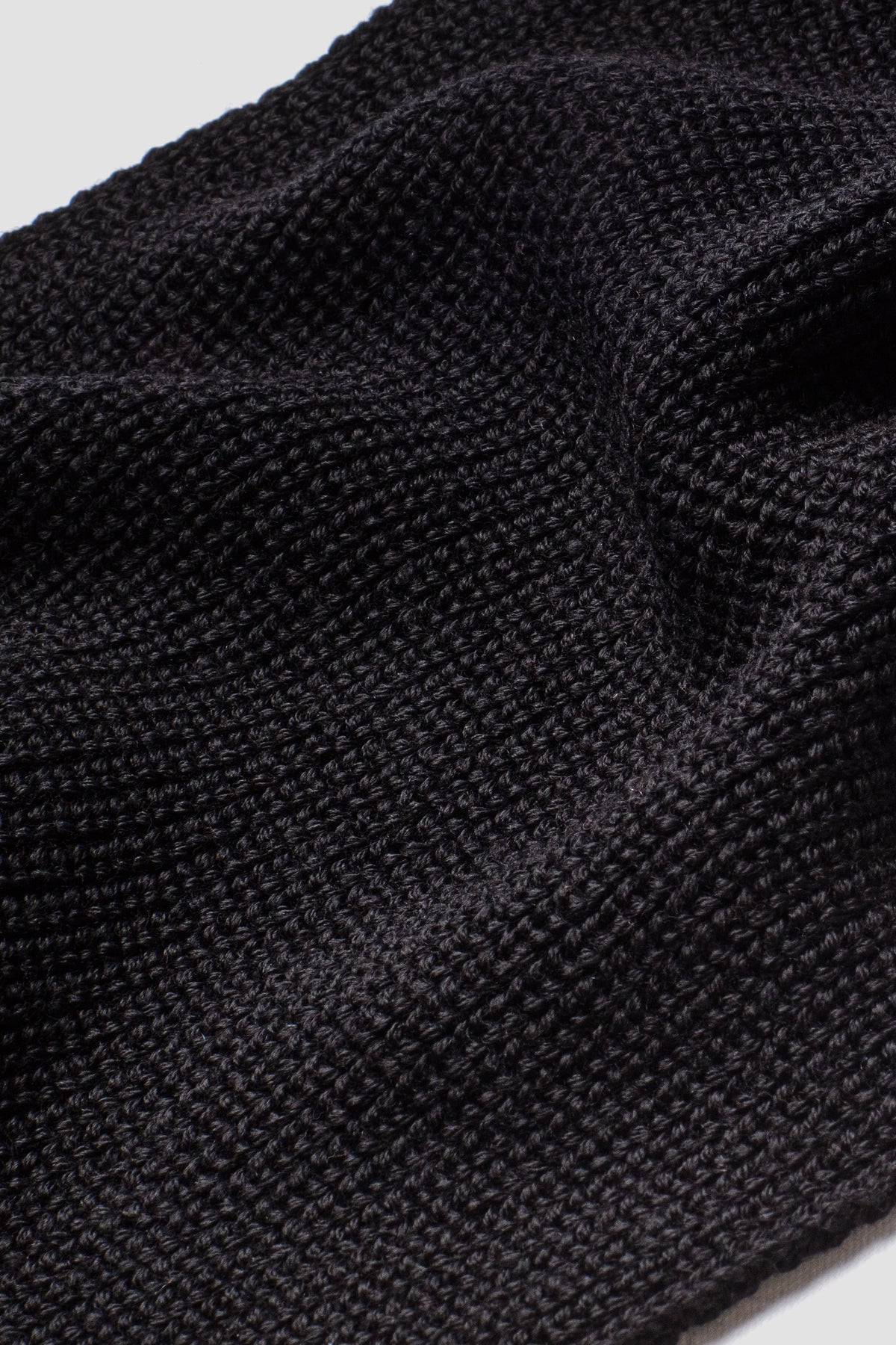 Écharpe homme et femme noire en laine mérinos, gros plan de la maille. Made in France.