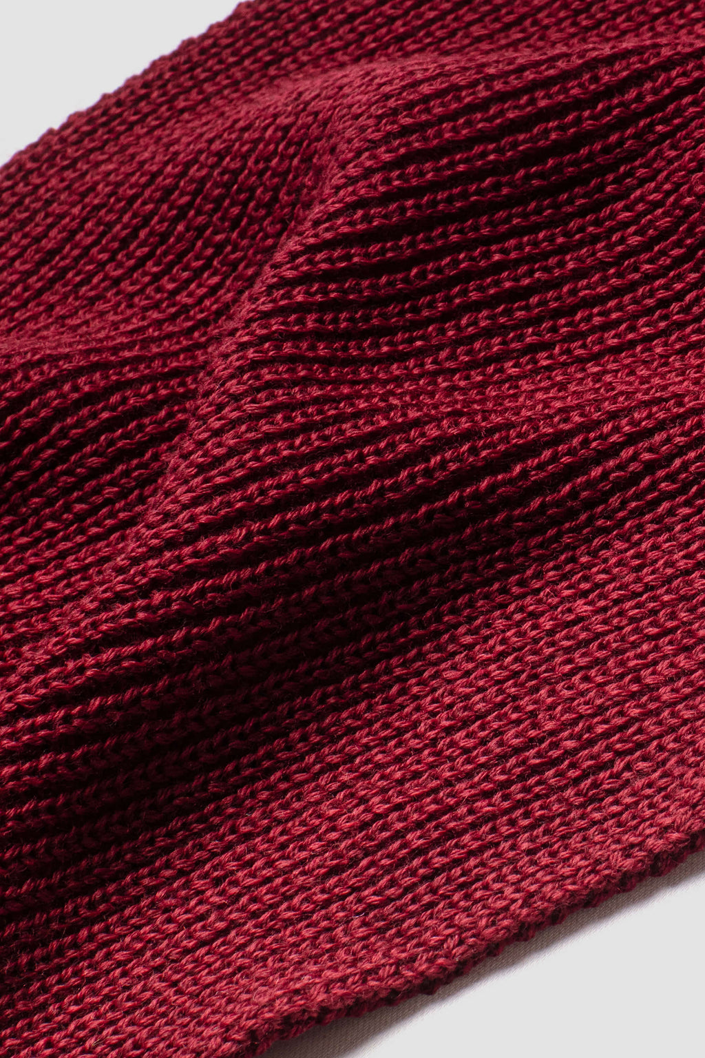 Écharpe rouge rubis en laine mérinos, gros plan de la maille. Made in France.