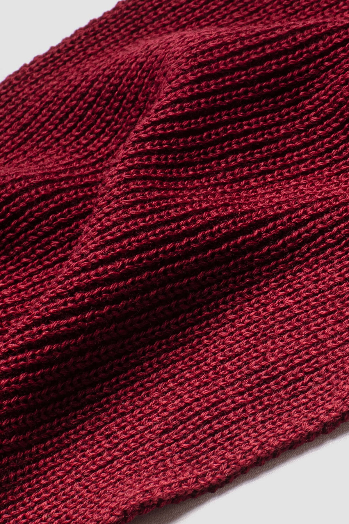 Écharpe rouge rubis en laine mérinos, gros plan de la maille. Made in France.