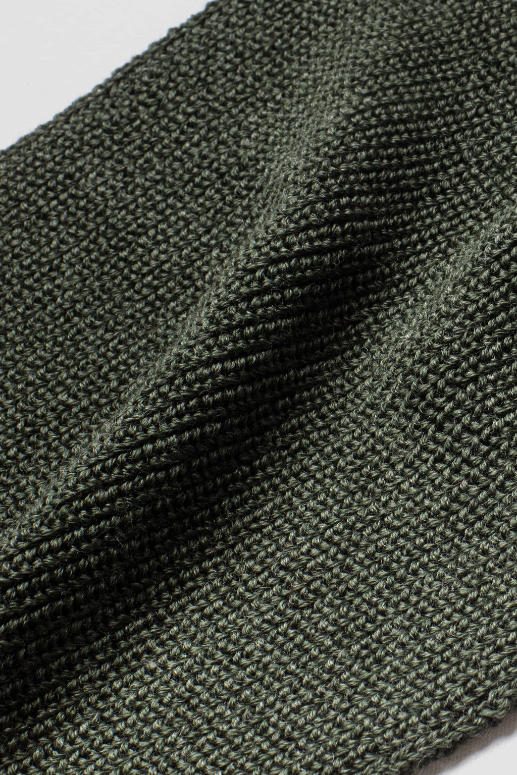 Écharpe vert kaki en laine mérinos, gros plan de la maille. Made in France.