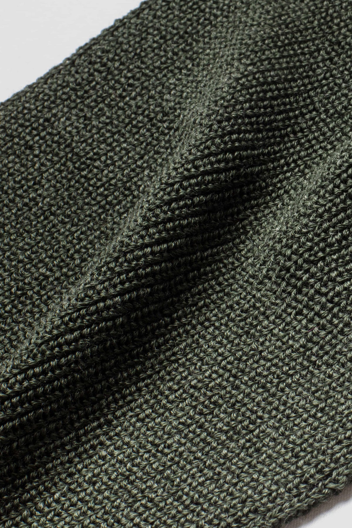 Écharpe vert kaki en laine mérinos, gros plan de la maille. Made in France.