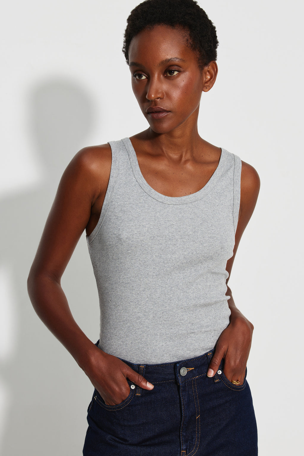 Débardeur Marcel Signature gris chiné femme en coton Pima côtelé, porté de face avec un jean bleu foncé, mains dans les poches.