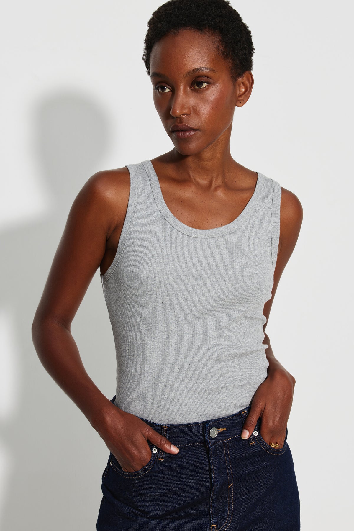 Débardeur Marcel Signature gris chiné femme en coton Pima côtelé, porté de face avec un jean bleu foncé, mains dans les poches.