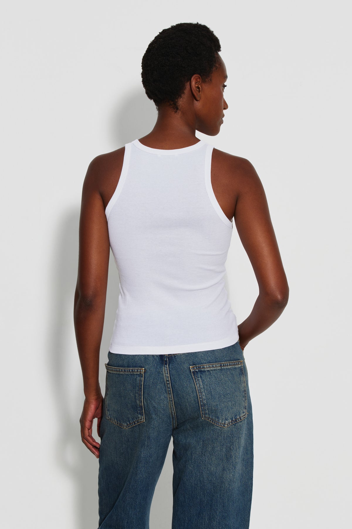 Débardeur Top Marcel blanc femme en coton Pima et élasthanne, porté de dos avec un jean bleu.