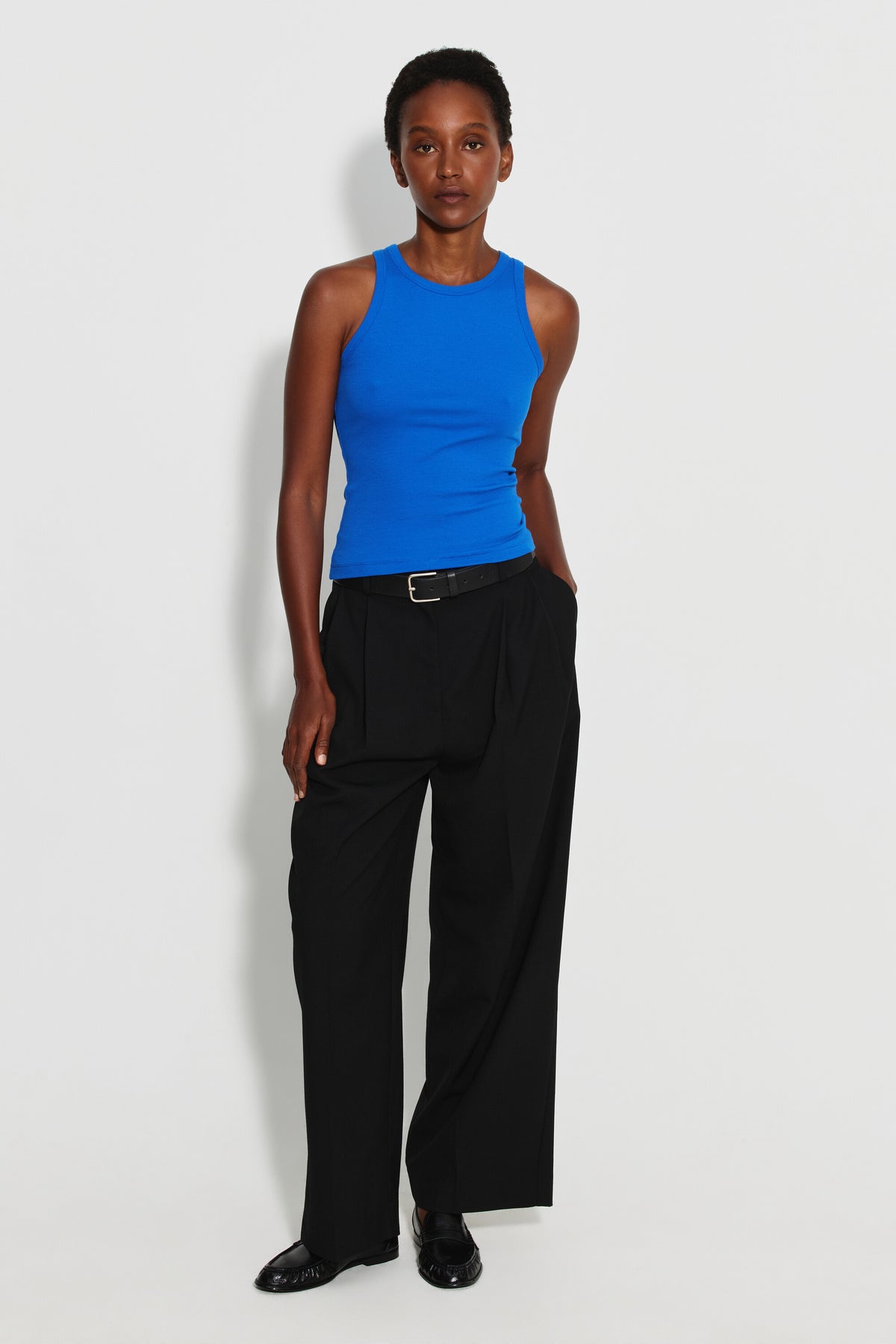 Débardeur Top Marcel bleu femme, porté avec un pantalon large noir et une ceinture noire, vue de face en pied.