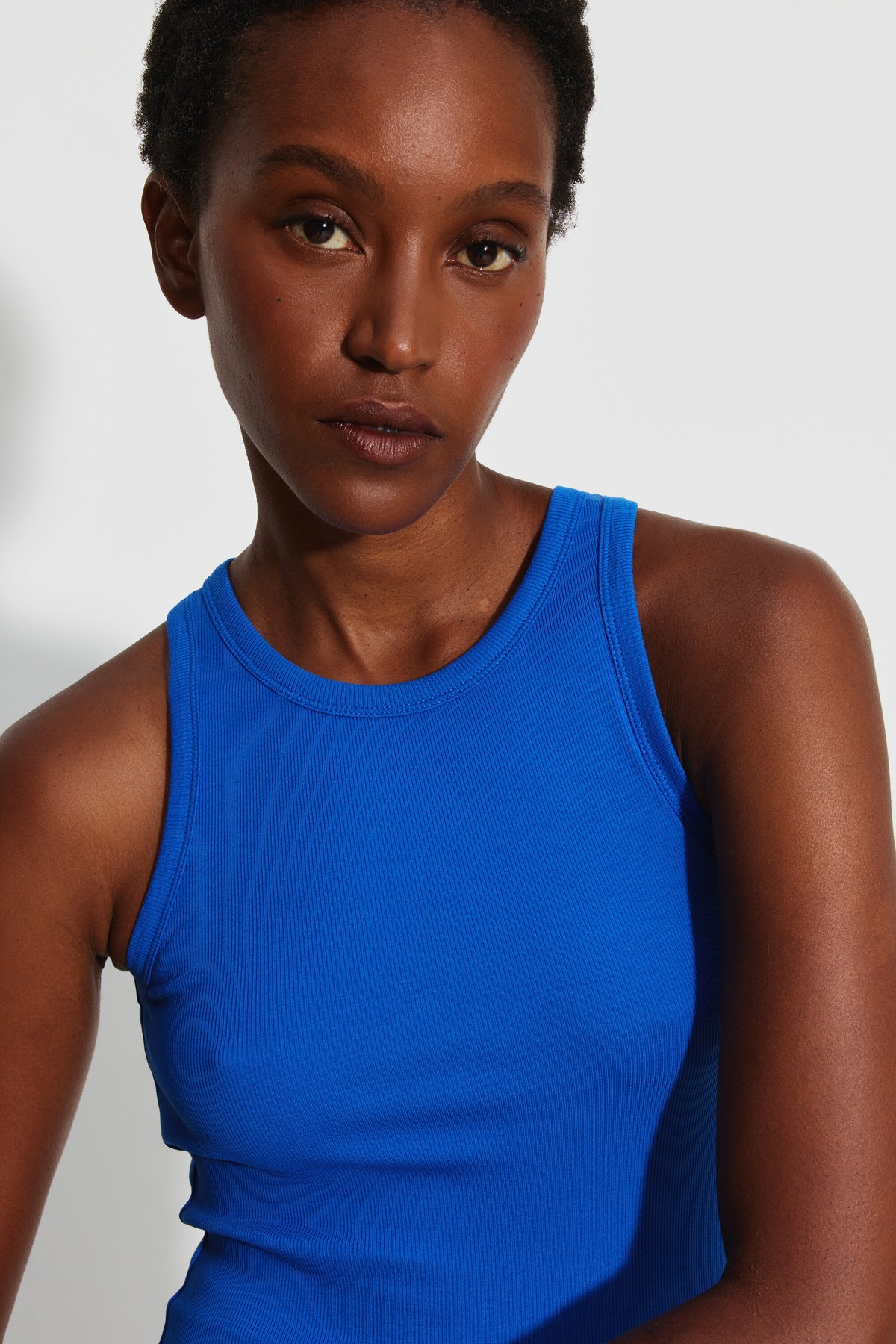 Débardeur Top Marcel bleu femme, portrait rapproché de face montrant l'encolure ronde et la maille côtelée.