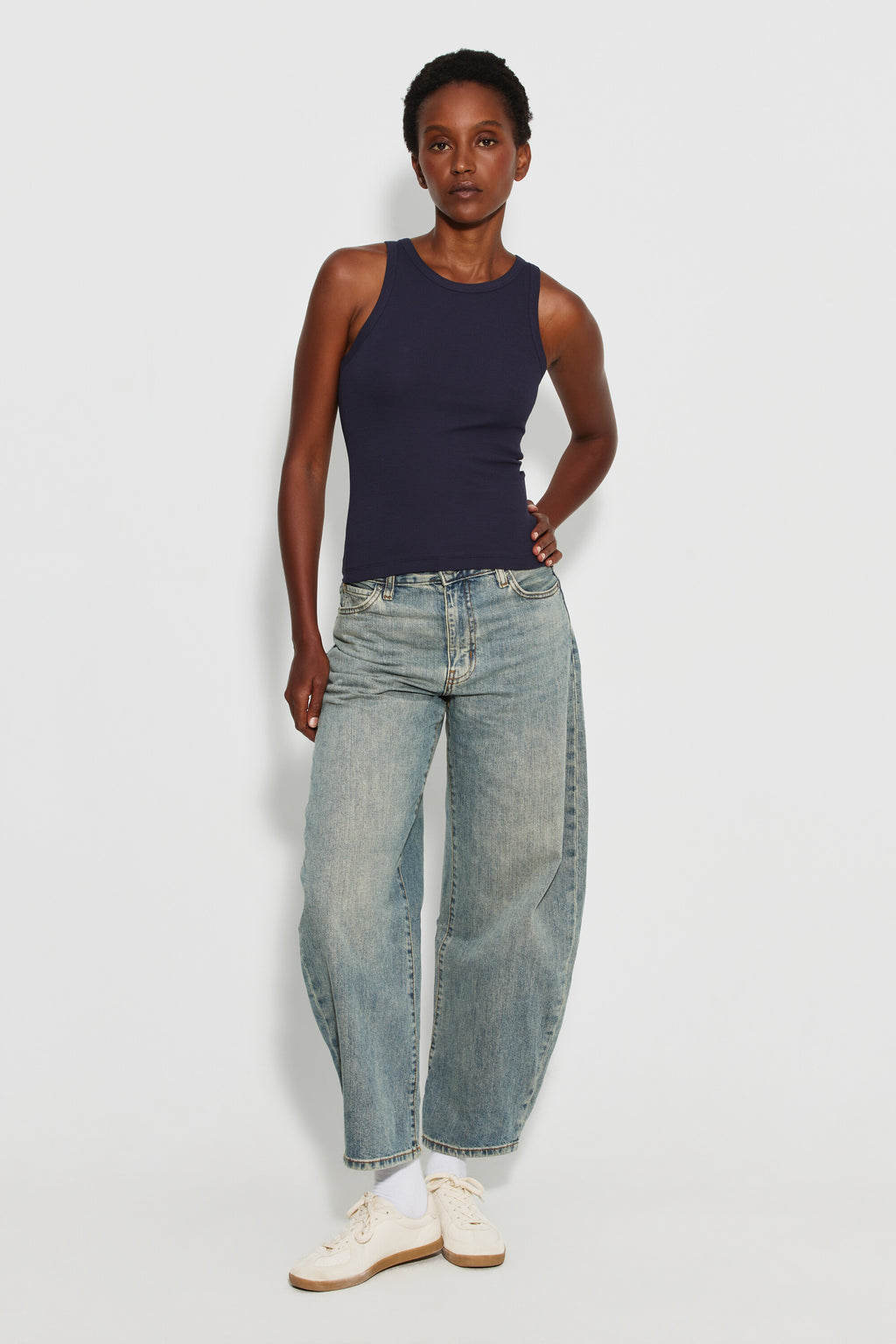 Débardeur Top Marcel bleu marine femme, porté avec un jean large bleu clair et des chaussures blanches, vue de face en pied.