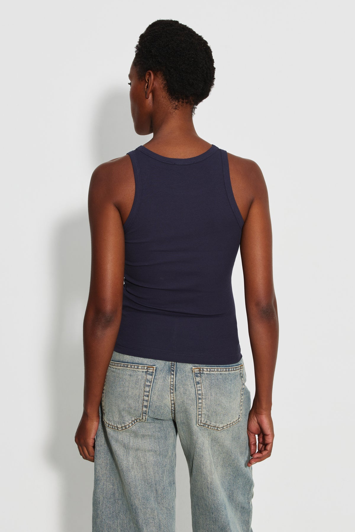 Débardeur Top Marcel bleu marine femme en coton Pima et élasthanne, porté de dos avec un jean bleu clair.