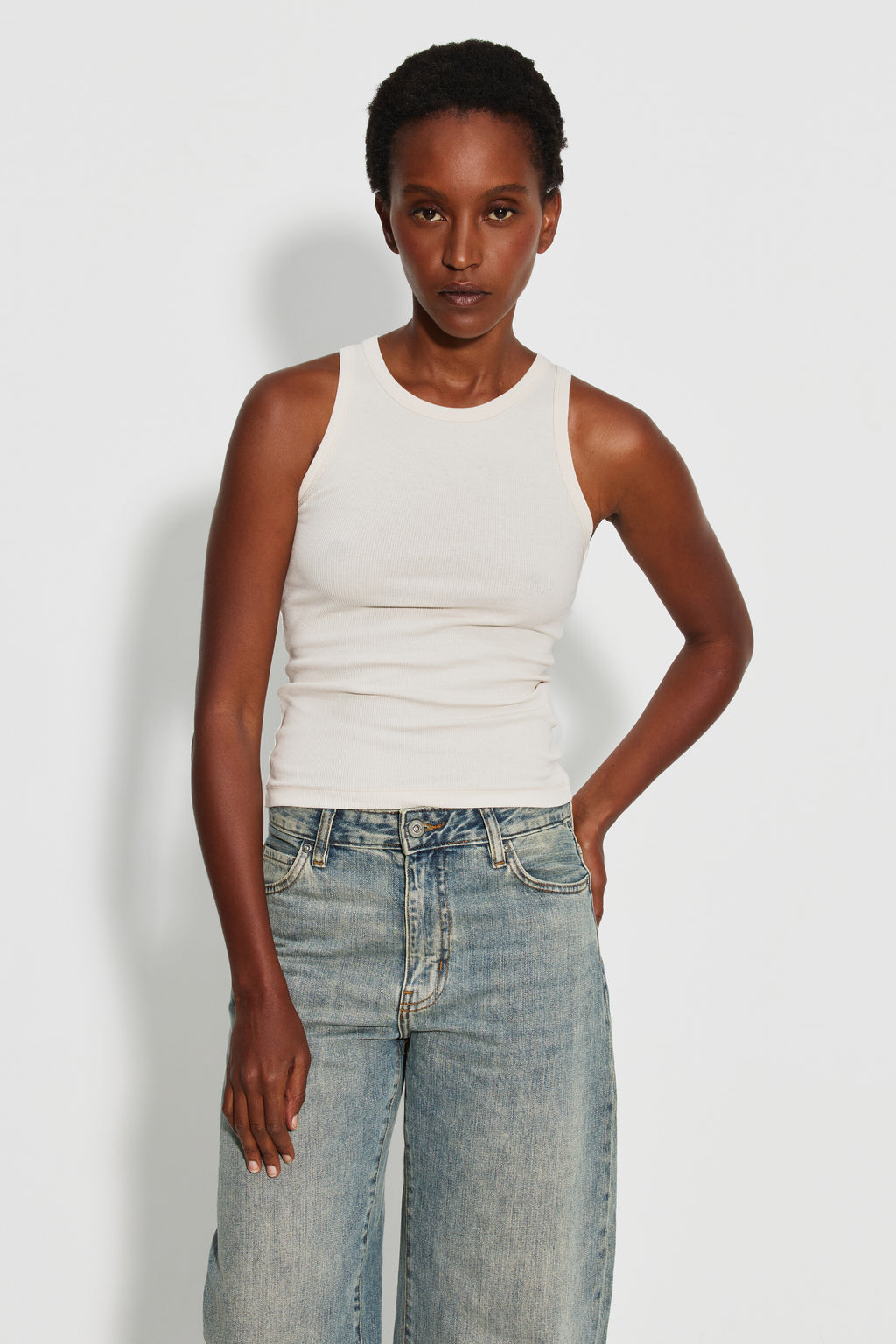 Débardeur Top Marcel écru femme, porté de face avec un jean bleu clair, une main dans la poche.