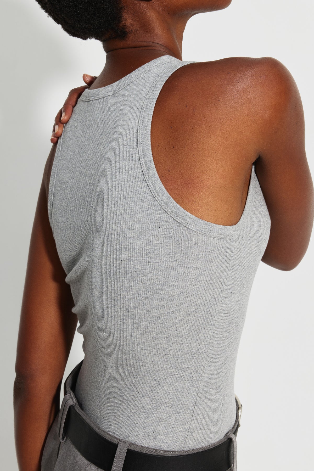 Débardeur Top Marcel gris femme, gros plan de dos montrant l'emmanchure et la maille chinée, une main sur l'épaule.