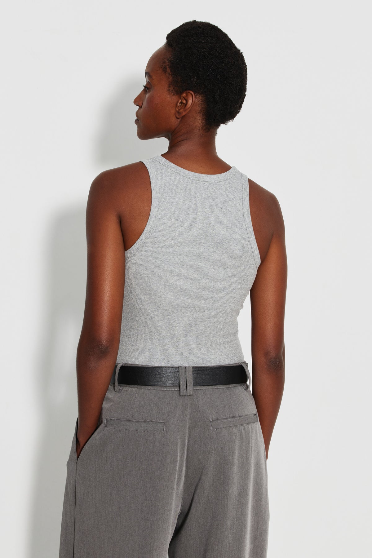 Débardeur Top Marcel gris femme en coton Pima et élasthanne, porté de dos avec un pantalon gris et une ceinture noire.