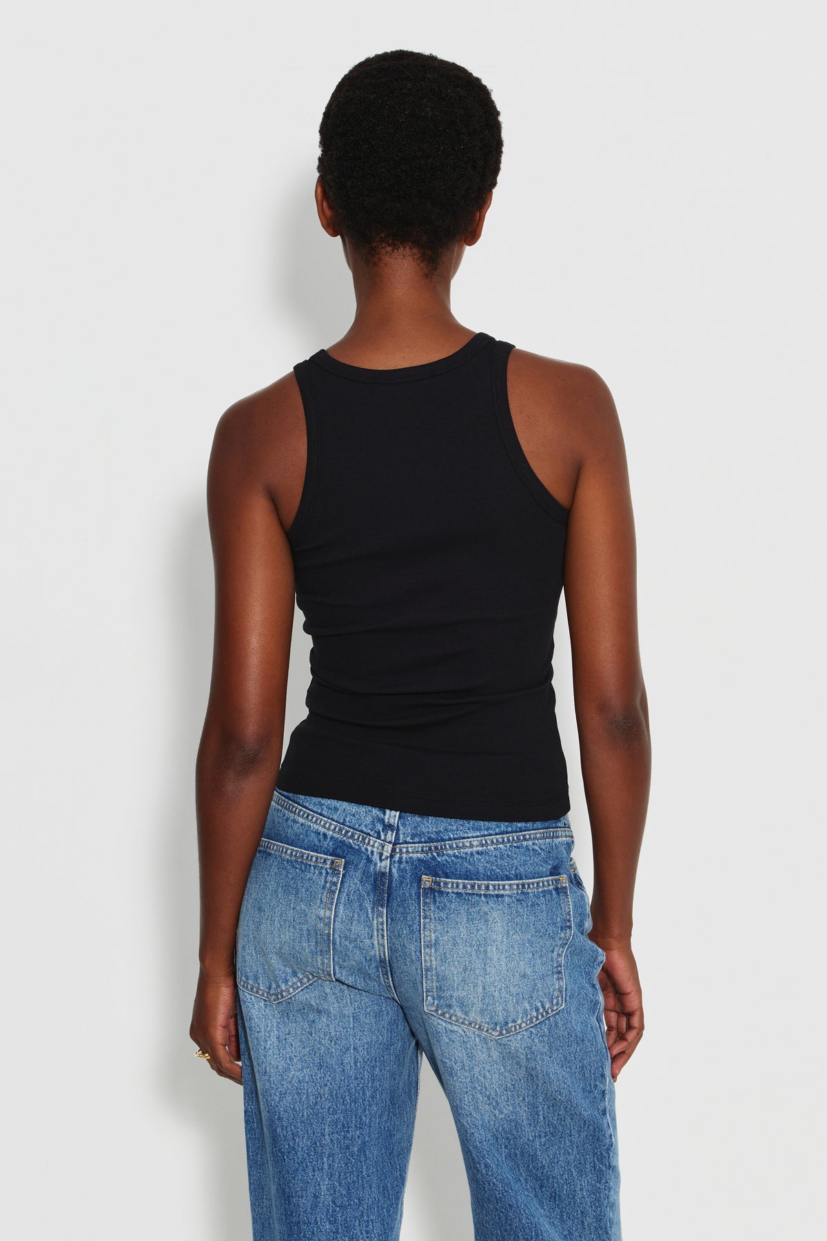 Débardeur Top Marcel noir femme en coton Pima et élasthanne, porté de dos avec un jean bleu.
