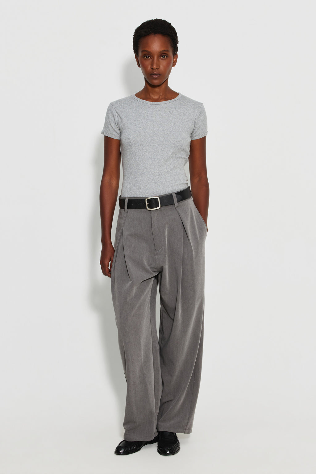 Maillot de corps femme gris chiné à manches courtes en coton Pima côtelé, porté avec un pantalon gris et une ceinture noire, vue de face en pied.