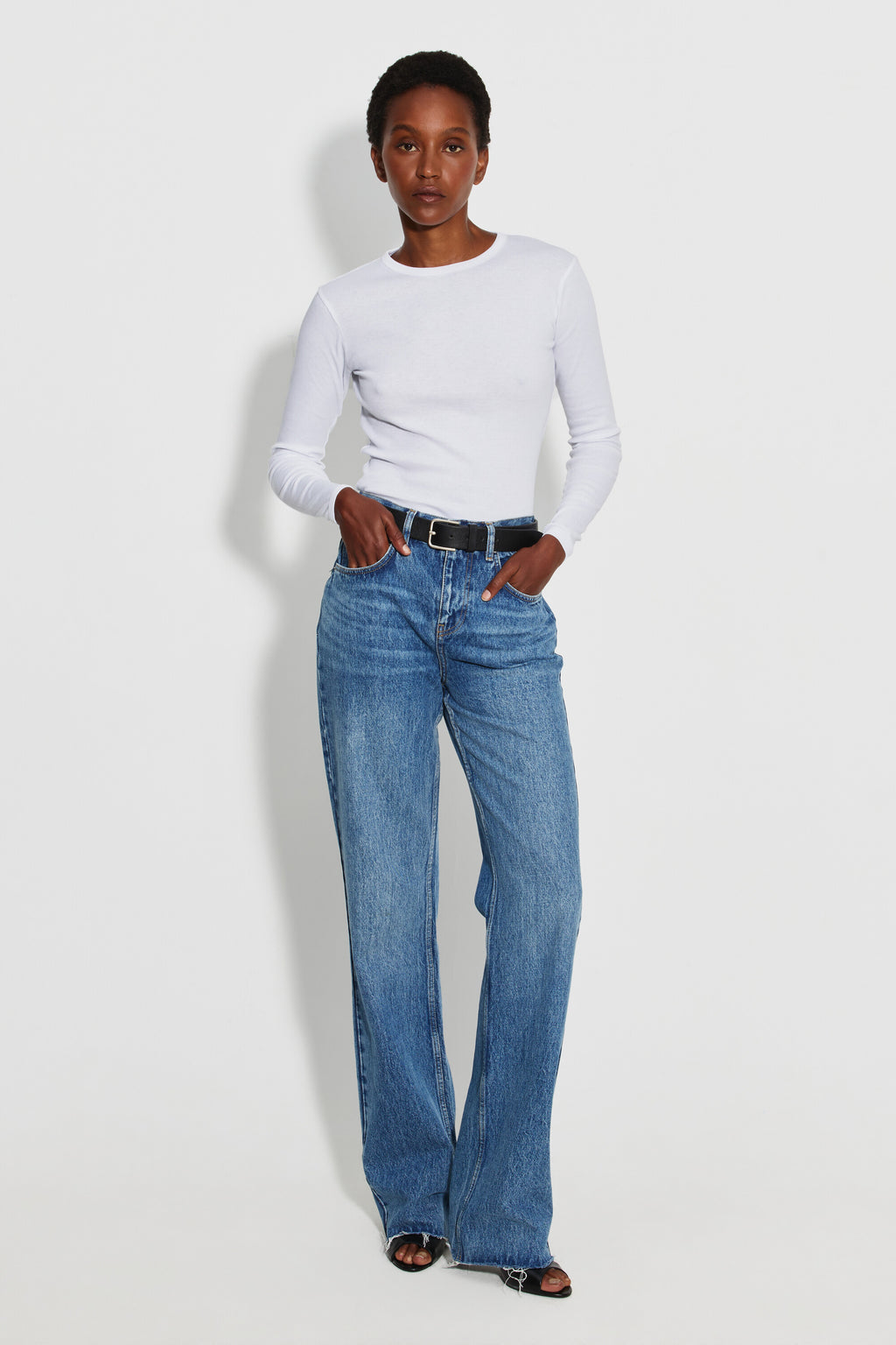 Maillot de corps femme blanc à manches longues en coton Pima, fabriqué à Roanne, porté avec un jean, vue en pied.