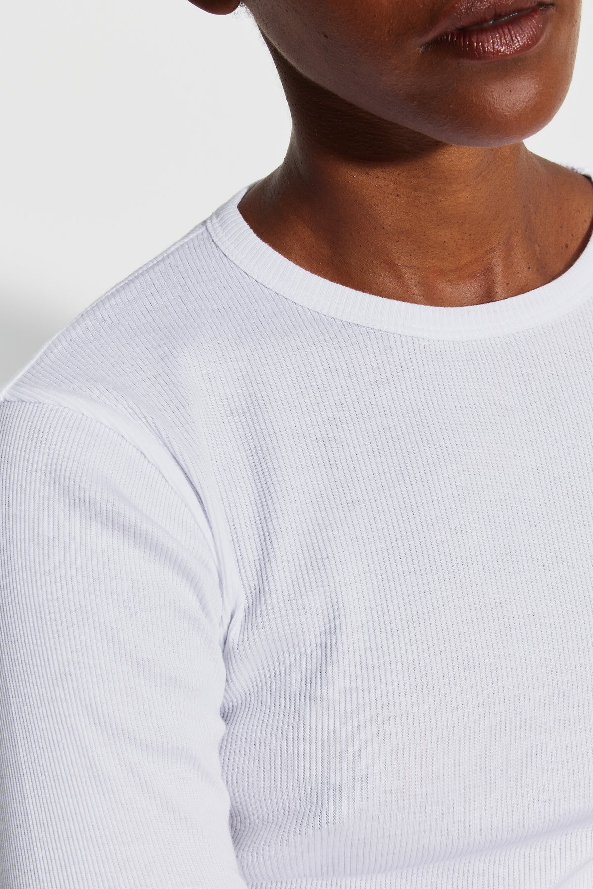 Détail du col rond et de la maille en coton Pima côtelé du maillot de corps femme blanc à manches longues.
