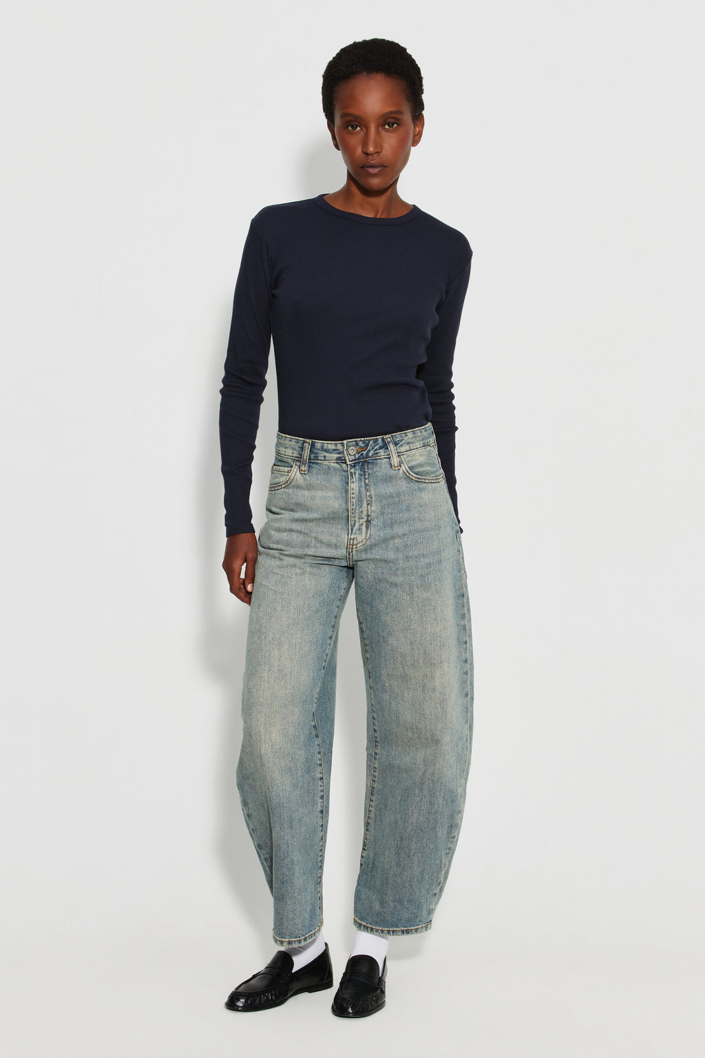 Maillot de corps femme bleu marine à manches longues en coton Pima, fabriqué à Roanne, porté avec un jean, vue en pied.