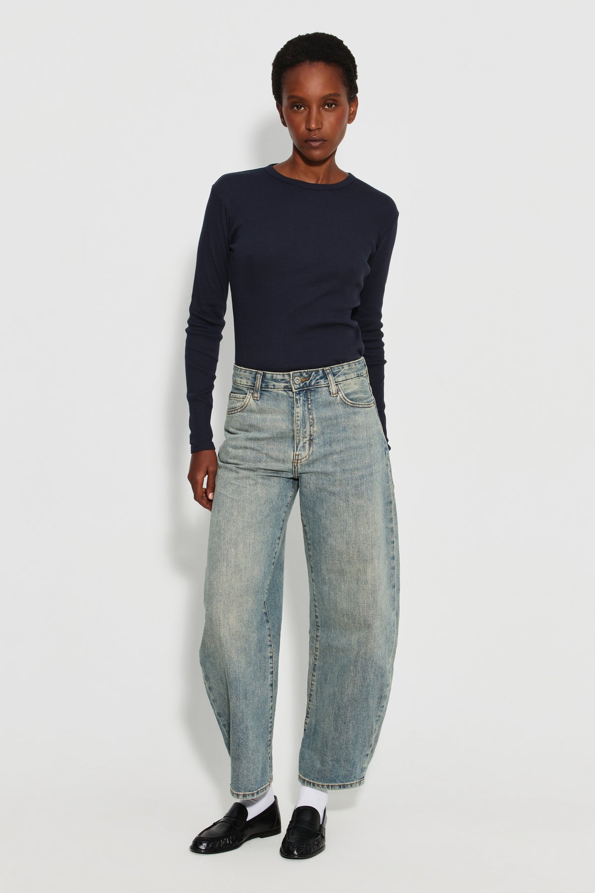 Maillot de corps femme bleu marine à manches longues en coton Pima, fabriqué à Roanne, porté avec un jean, vue en pied.