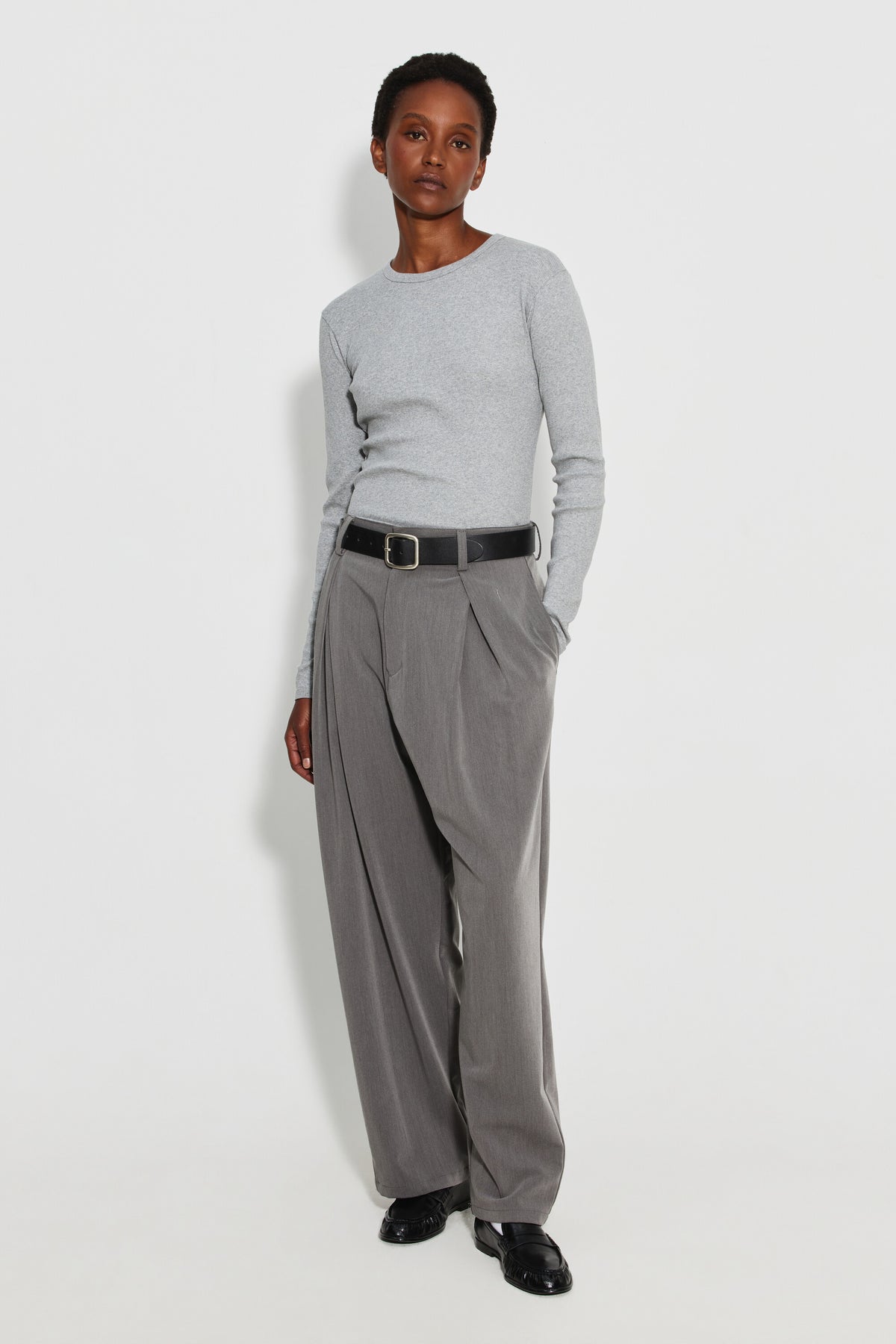 Maillot de corps femme gris chiné à manches longues en coton Pima, fabriqué à Roanne, porté avec un pantalon gris, vue en pied.