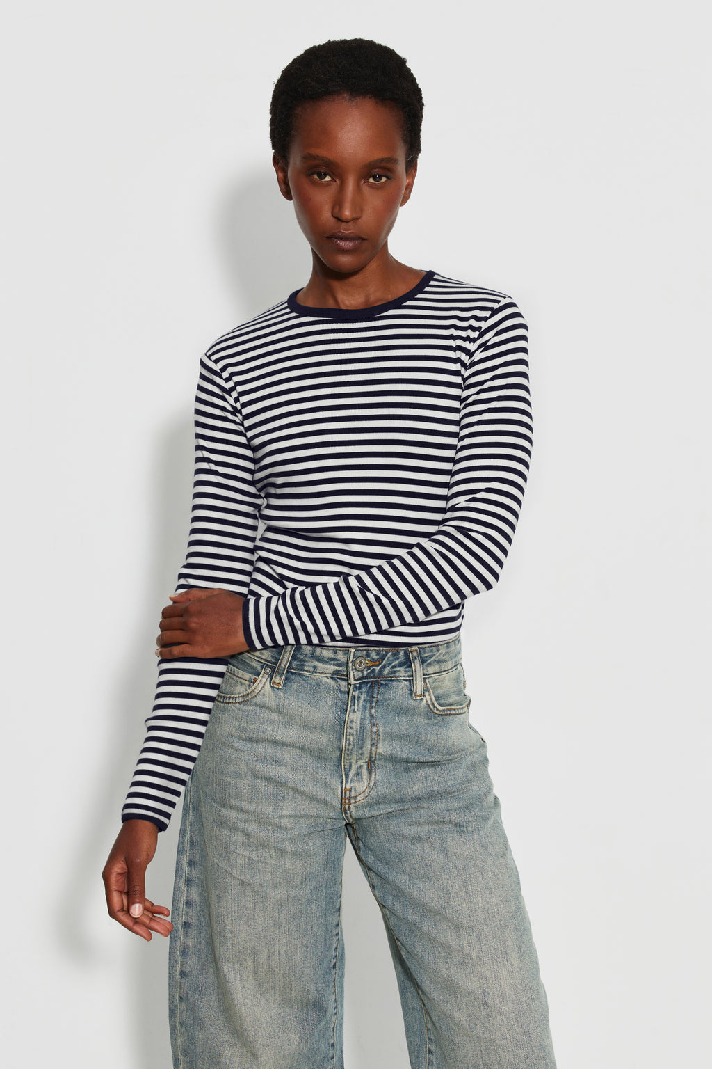 Maillot de corps femme bleu marine et écru en coton bio côtelé à manches longues, porté avec un jean bleu clair, vue de face. Made in France.