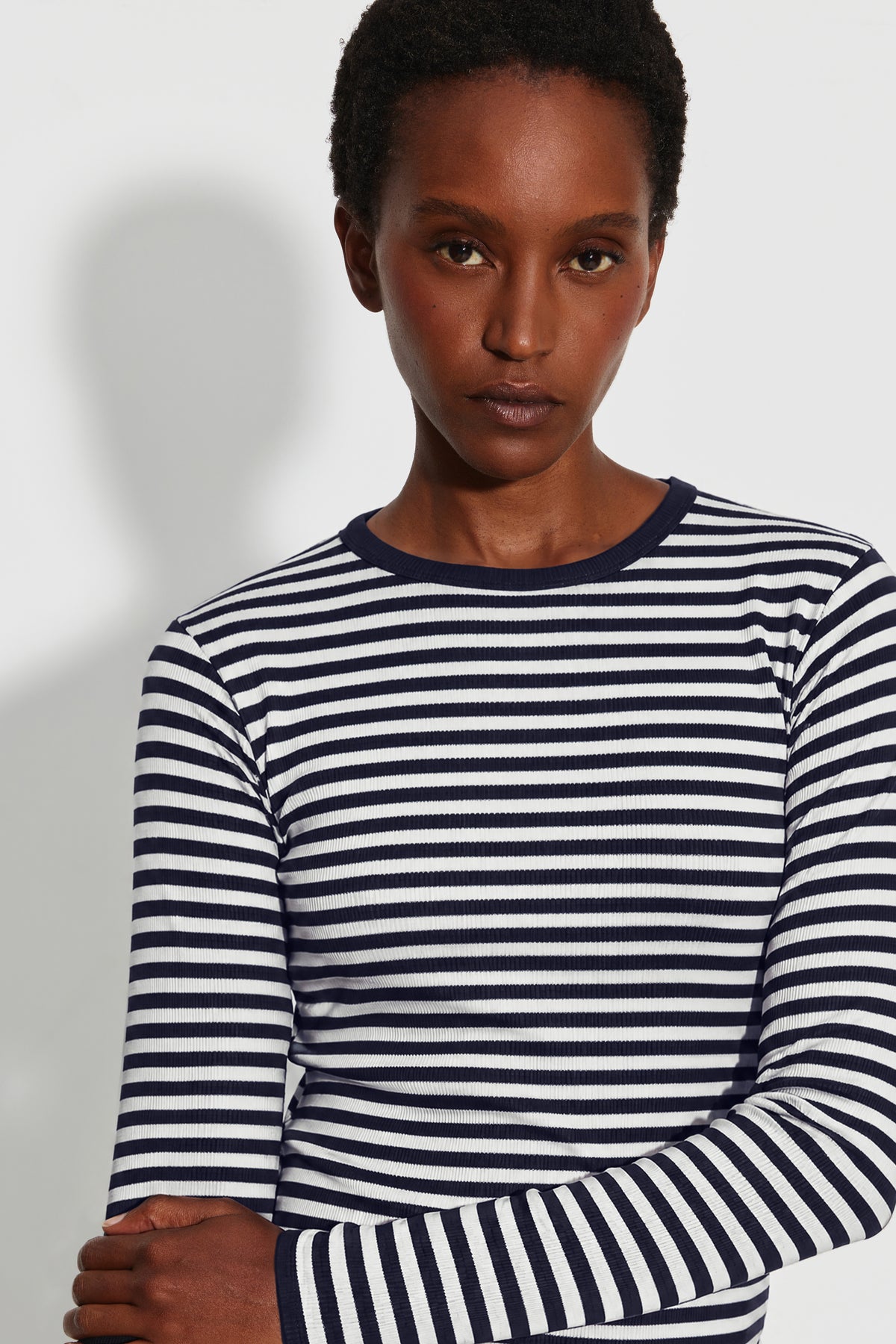 Maillot de corps femme bleu marine et écru en coton bio côtelé à manches longues, portrait rapproché montrant les rayures et le col rond bleu marine.