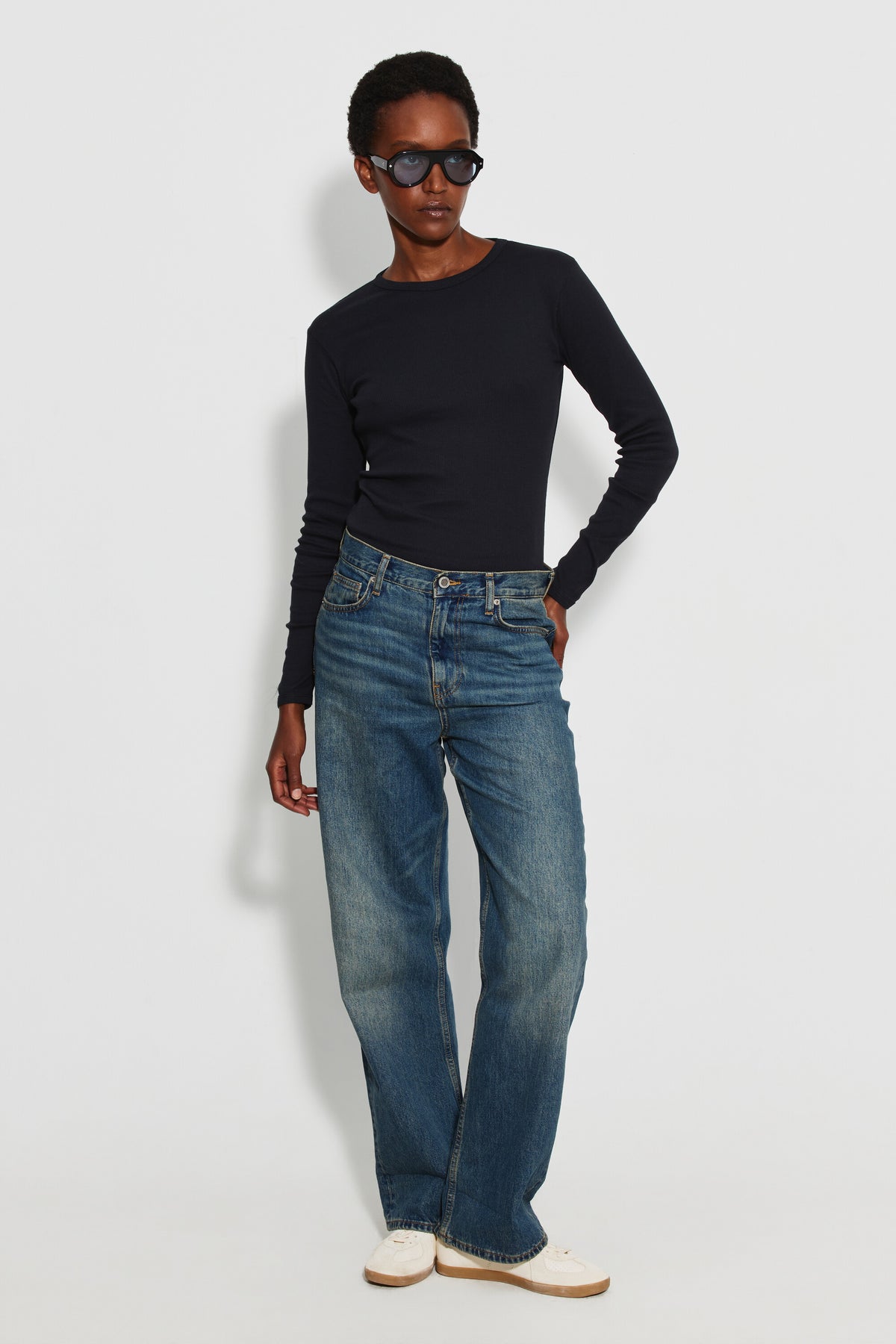 Maillot de corps femme noir à manches longues en coton Pima, fabriqué à Roanne, porté avec un jean, vue en pied.