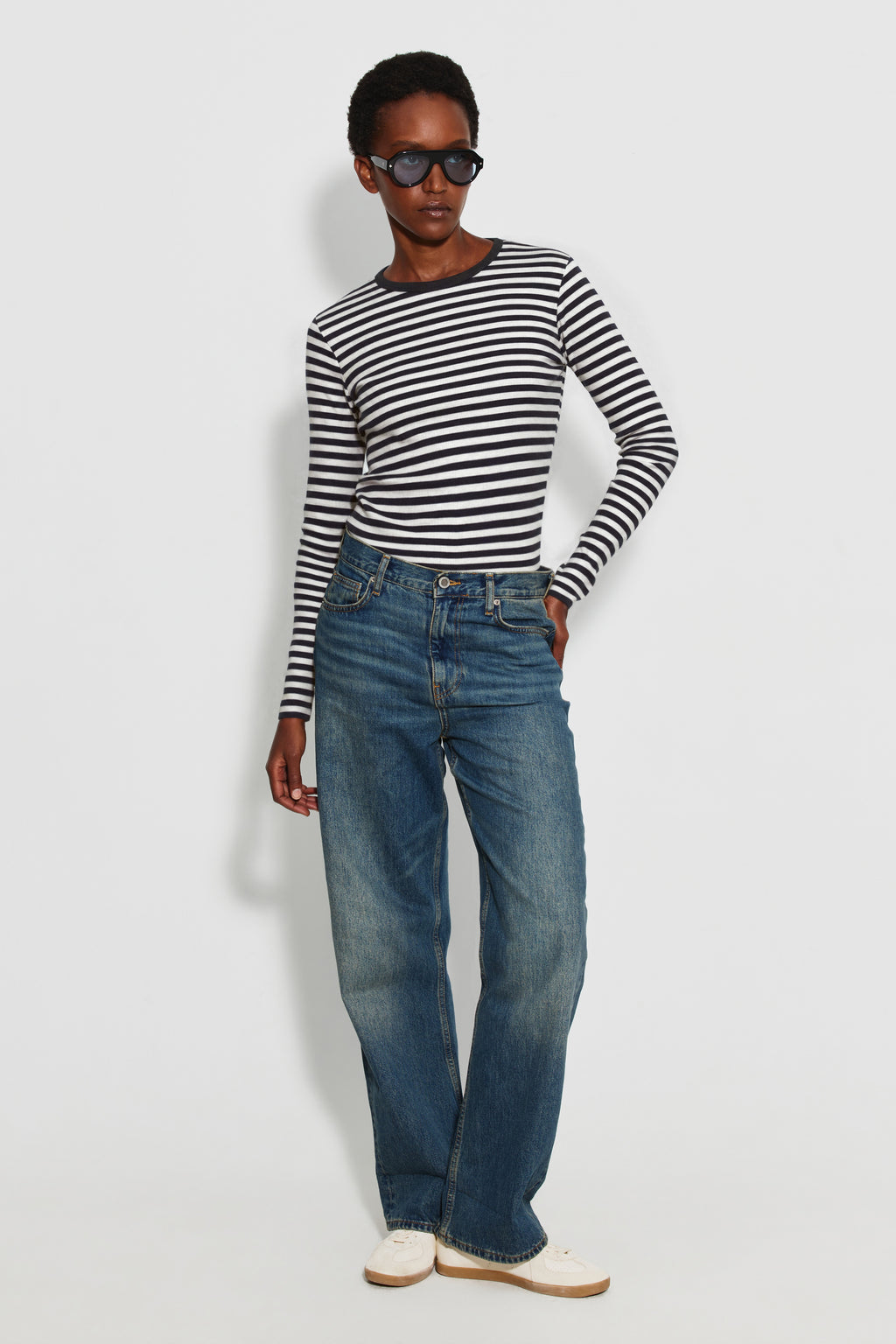 Maillot de corps femme noir et écru en coton bio côtelé à manches longues, porté avec un jean bleu, vue en pied.