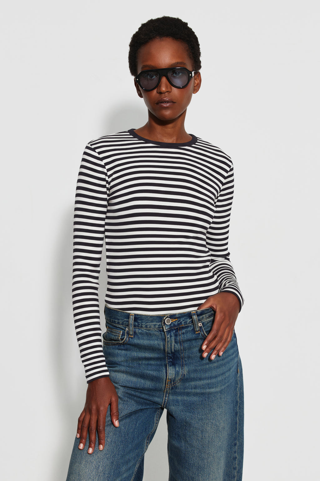 Maillot de corps femme noir et écru en coton bio côtelé à manches longues, porté avec un jean bleu, vue de face. Made in France.