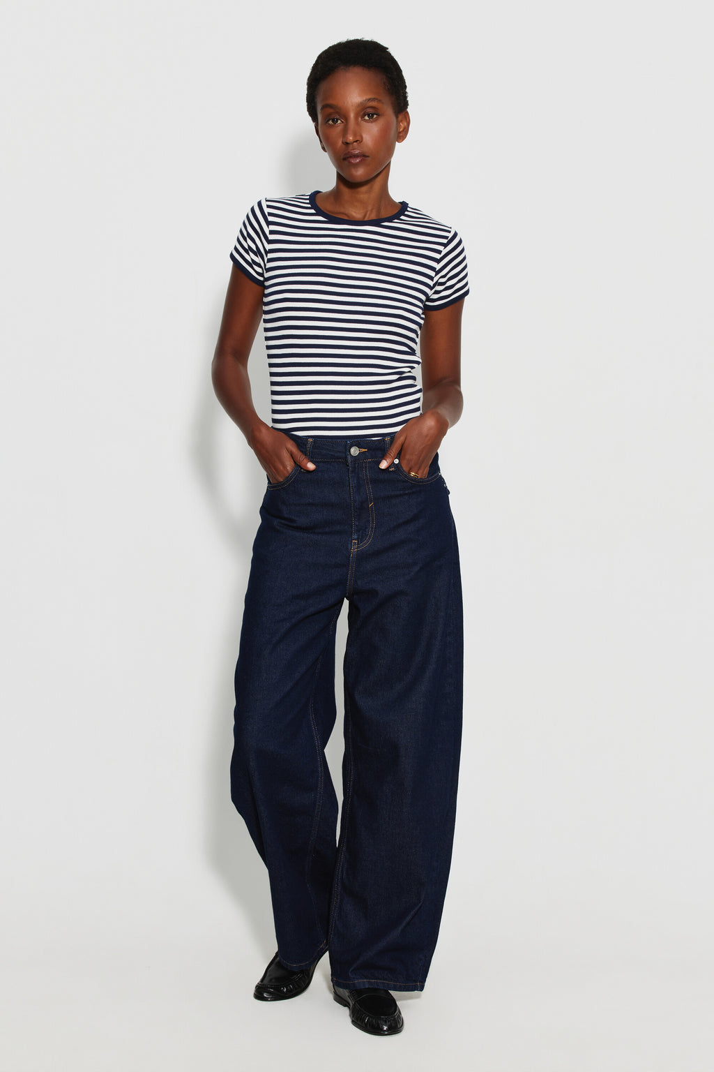 Maillot de corps femme bleu marine et écru en coton bio côtelé à manches courtes, porté avec un jean large bleu foncé, vue de face en pied.
