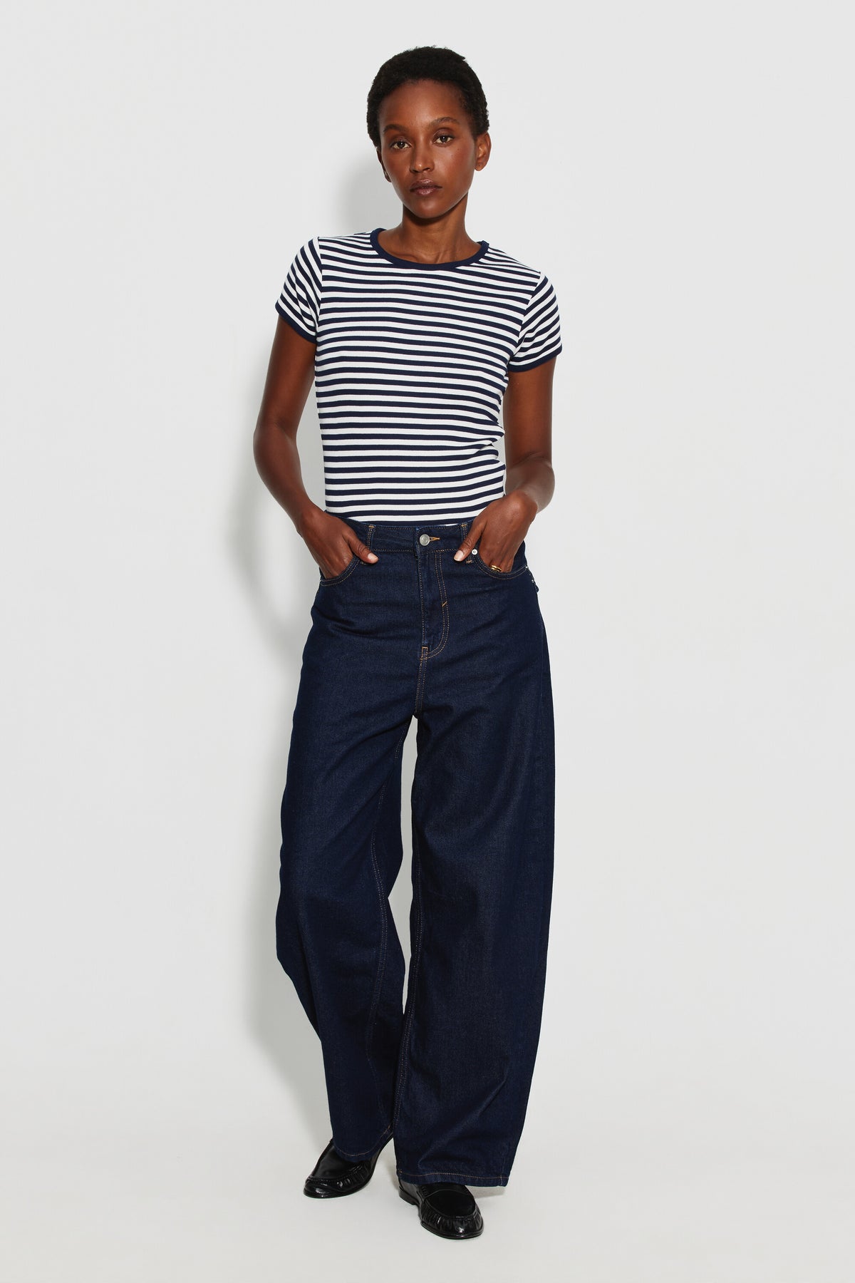 Maillot de corps femme marinière bleu marine et écru, porté avec un jean large bleu foncé, vue de face en pied.