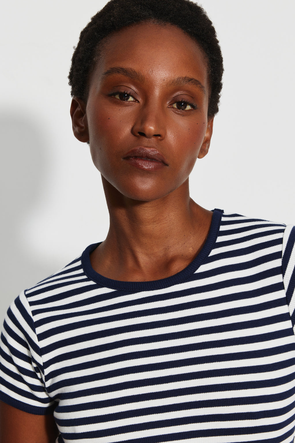 Maillot de corps femme bleu marine et écru en coton bio côtelé à manches courtes, portrait rapproché montrant les rayures et le col rond bleu marine.