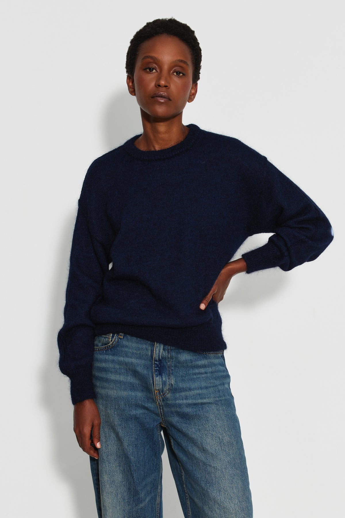 Pull mohair à manches longues femme bleu marine – vue de face, une main à la taille.