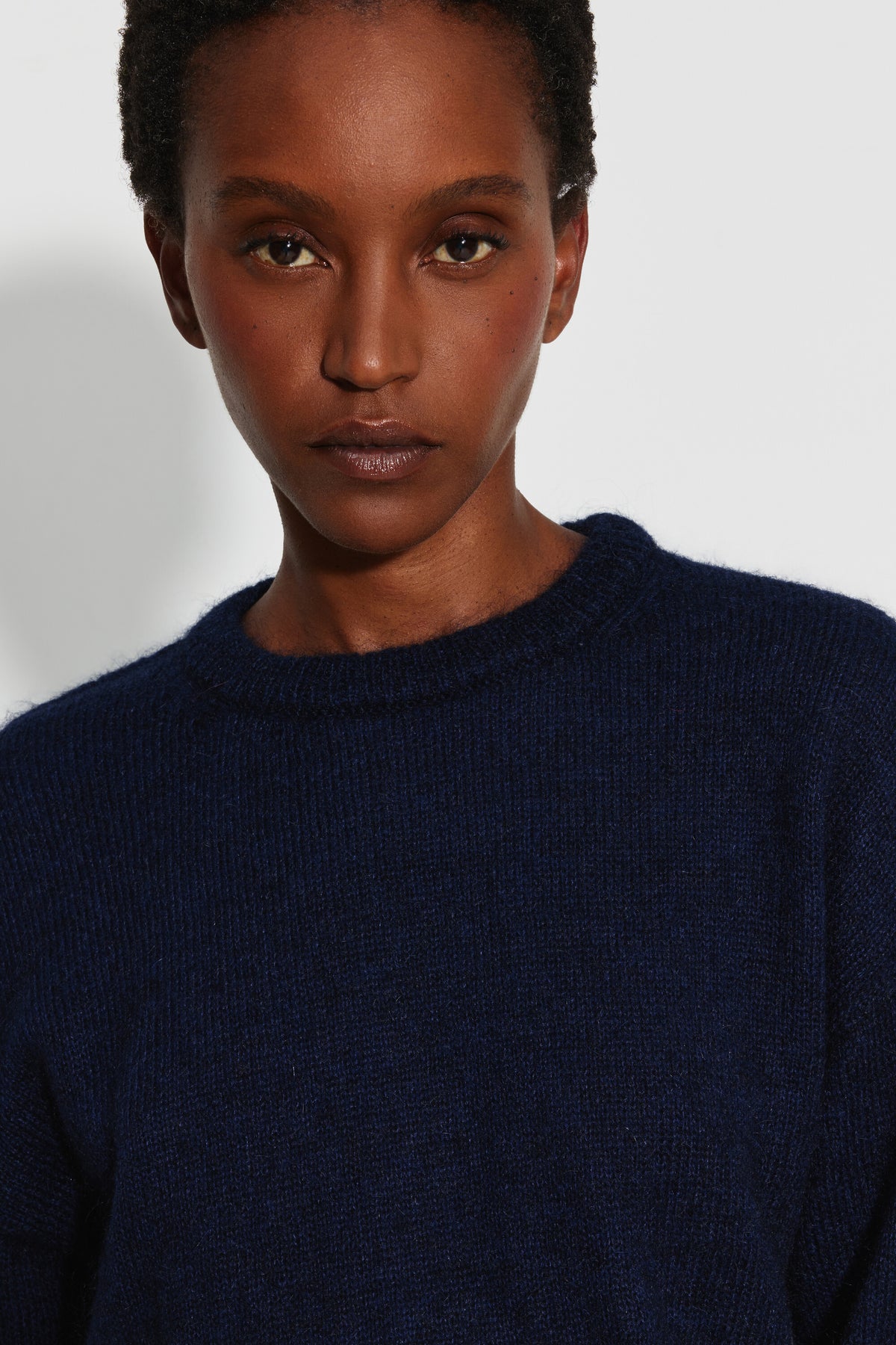 Pull mohair à manches longues femme bleu marine – portrait rapproché montrant le col rond et la maille duveteuse.
