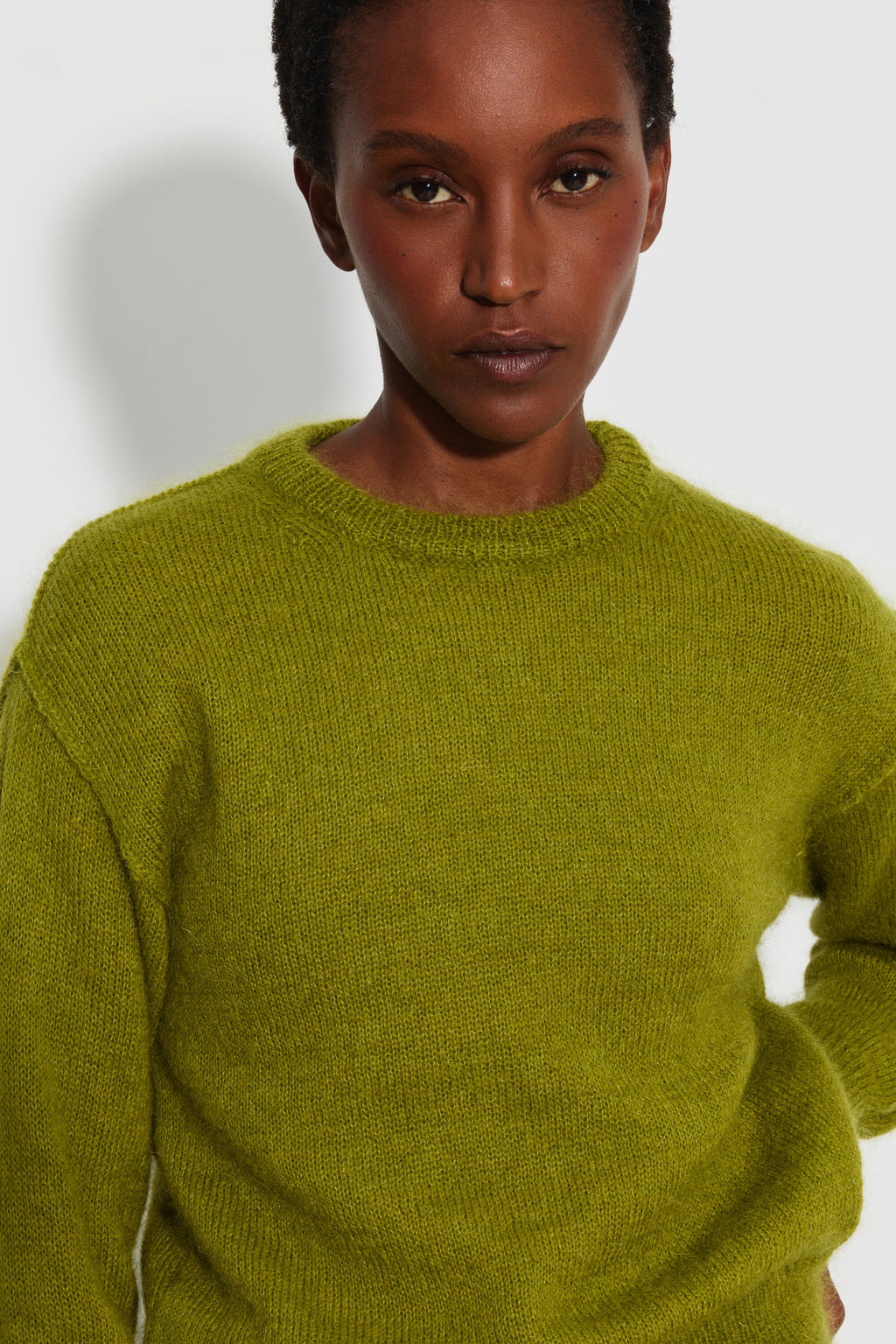 Pull mohair à manches longues femme vert mousse – portrait rapproché montrant le col rond et la maille duveteuse.