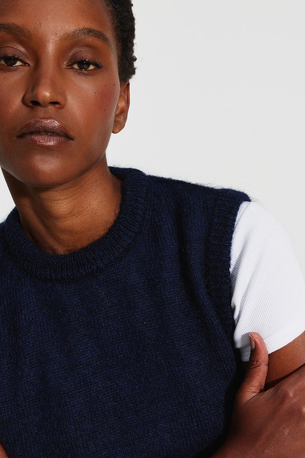 Pull mohair sans manches femme bleu marine – portrait rapproché montrant le col rond et l'emmanchure sur un tee-shirt blanc.