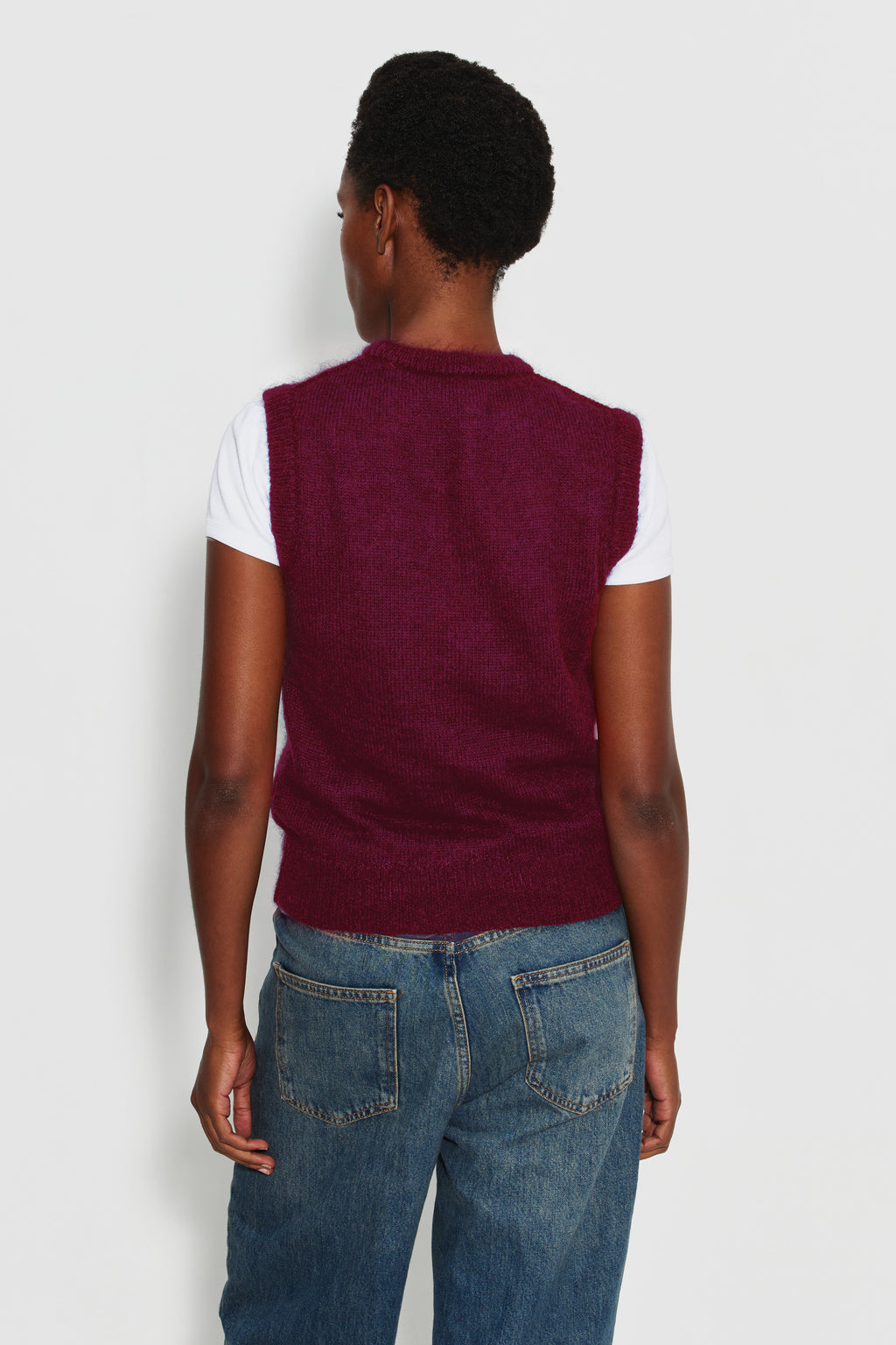 Pull femme bordeaux en mohair sans manches, vue de dos sur un maillot de corps blanc.