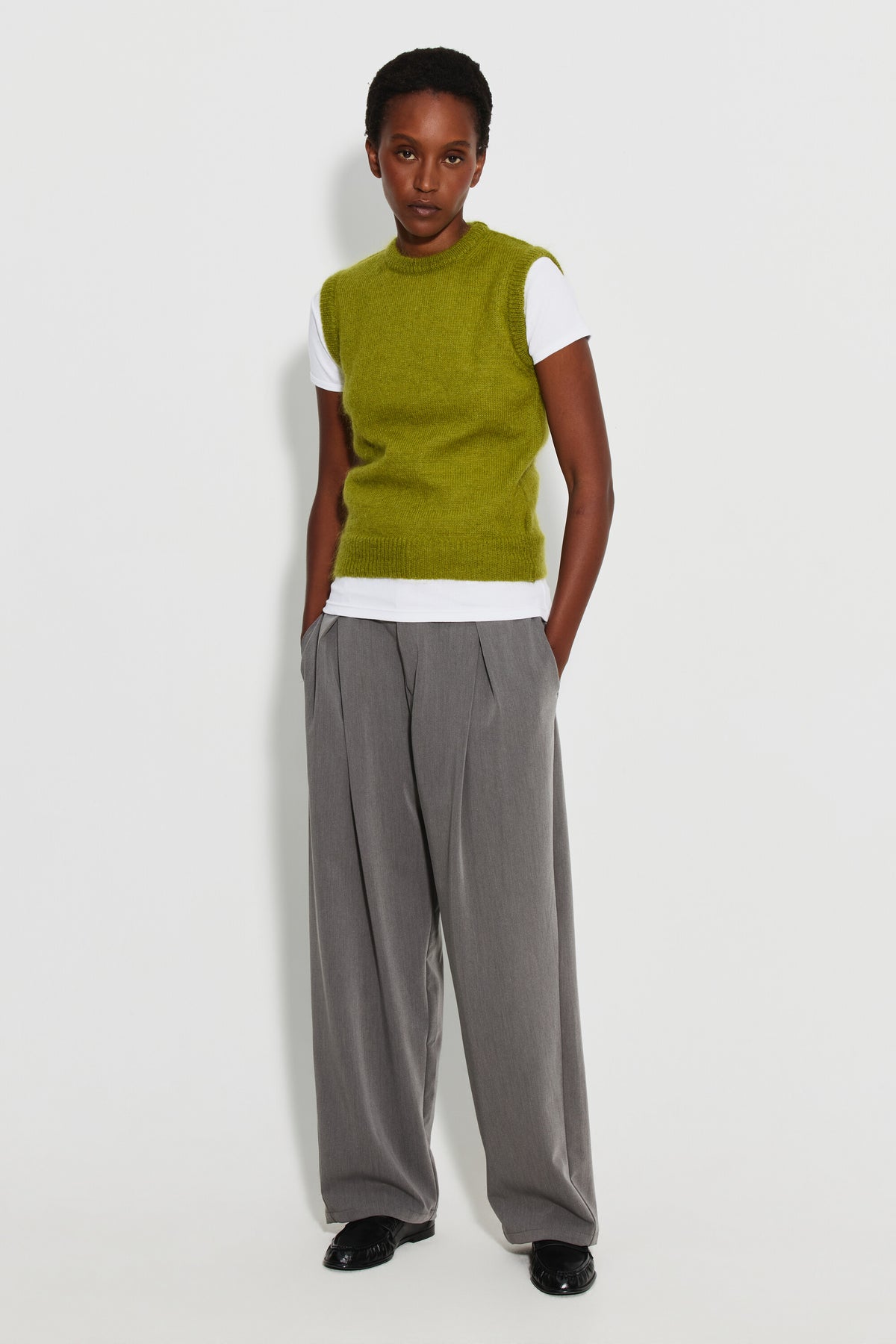 Pull mohair sans manches femme vert mousse – vue de face en pied, porté sur un tee-shirt blanc avec un pantalon gris.