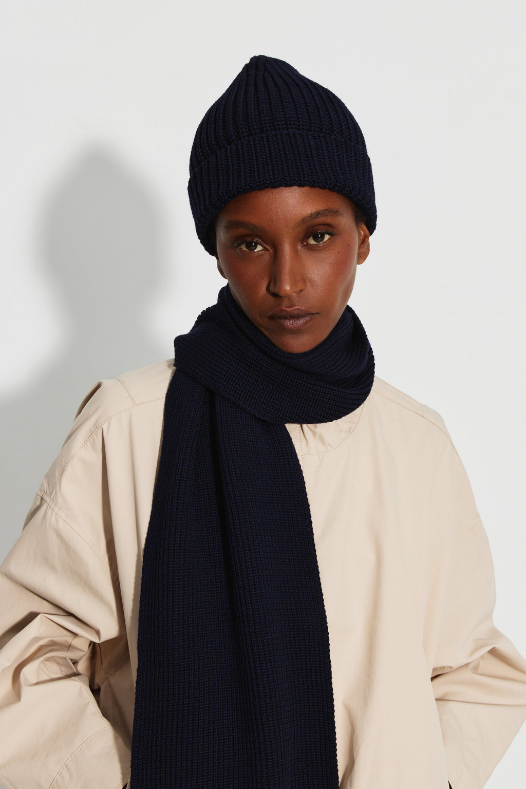 Bonnet femme bleu marine en laine mérinos, portrait de face montrant le revers du bonnet, avec une écharpe bleu marine. Made in France.