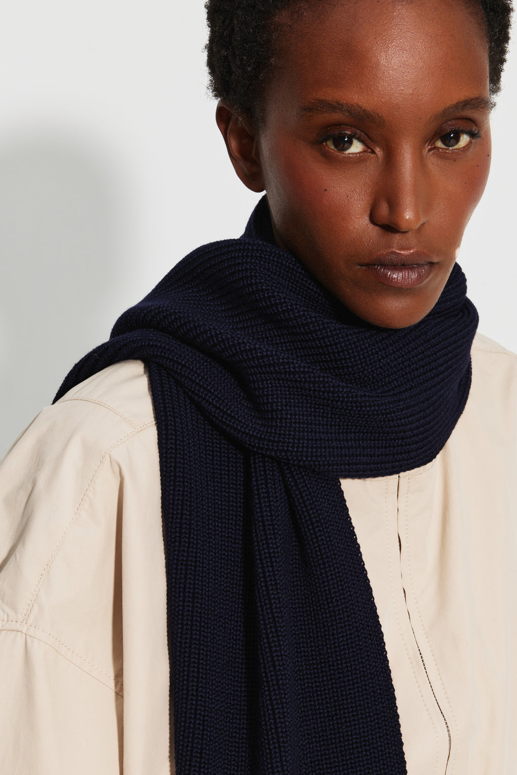 Écharpe femme bleu marine en laine mérinos, portrait rapproché montrant la maille de l’écharpe enroulée autour du cou.