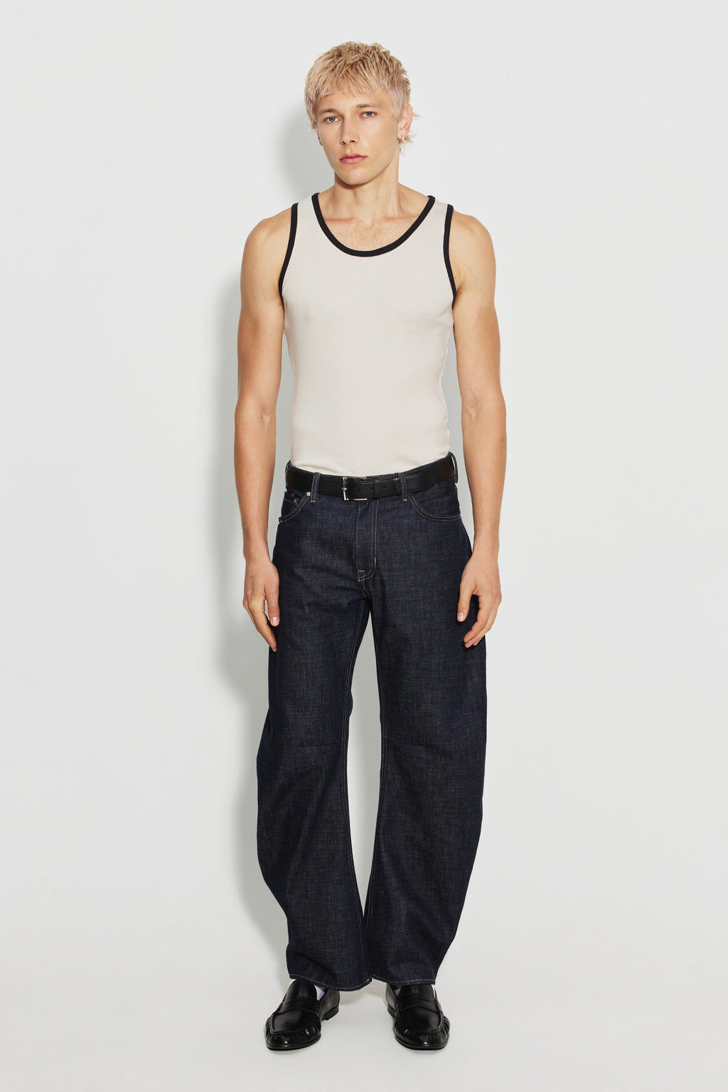 Débardeur homme écru et noir en coton Pima, porté avec un jean foncé et des chaussures noires, vue de face en pied.